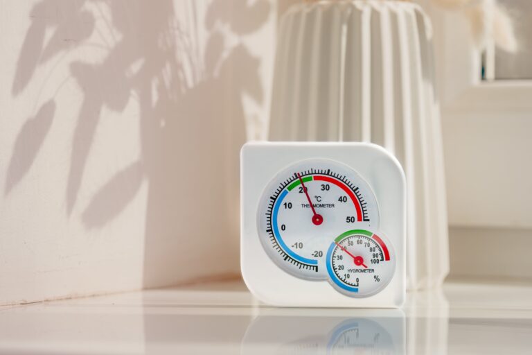 Witte thermometer en vochtmeter op een wit oppervlak met een schaduw